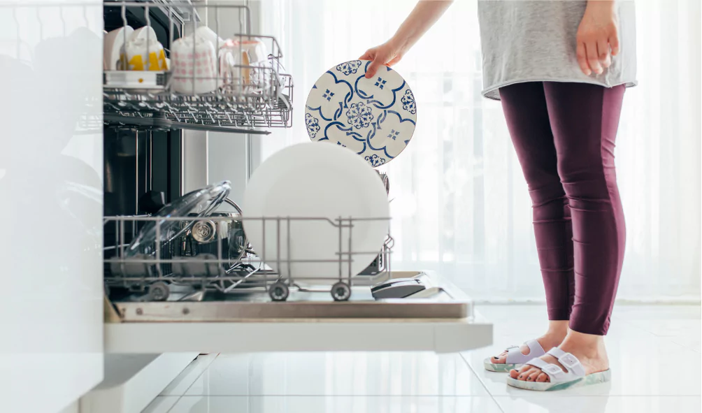 woman putting dishes into dishwasher