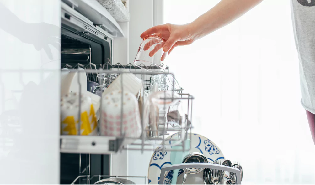 person putting glass in dishwasher